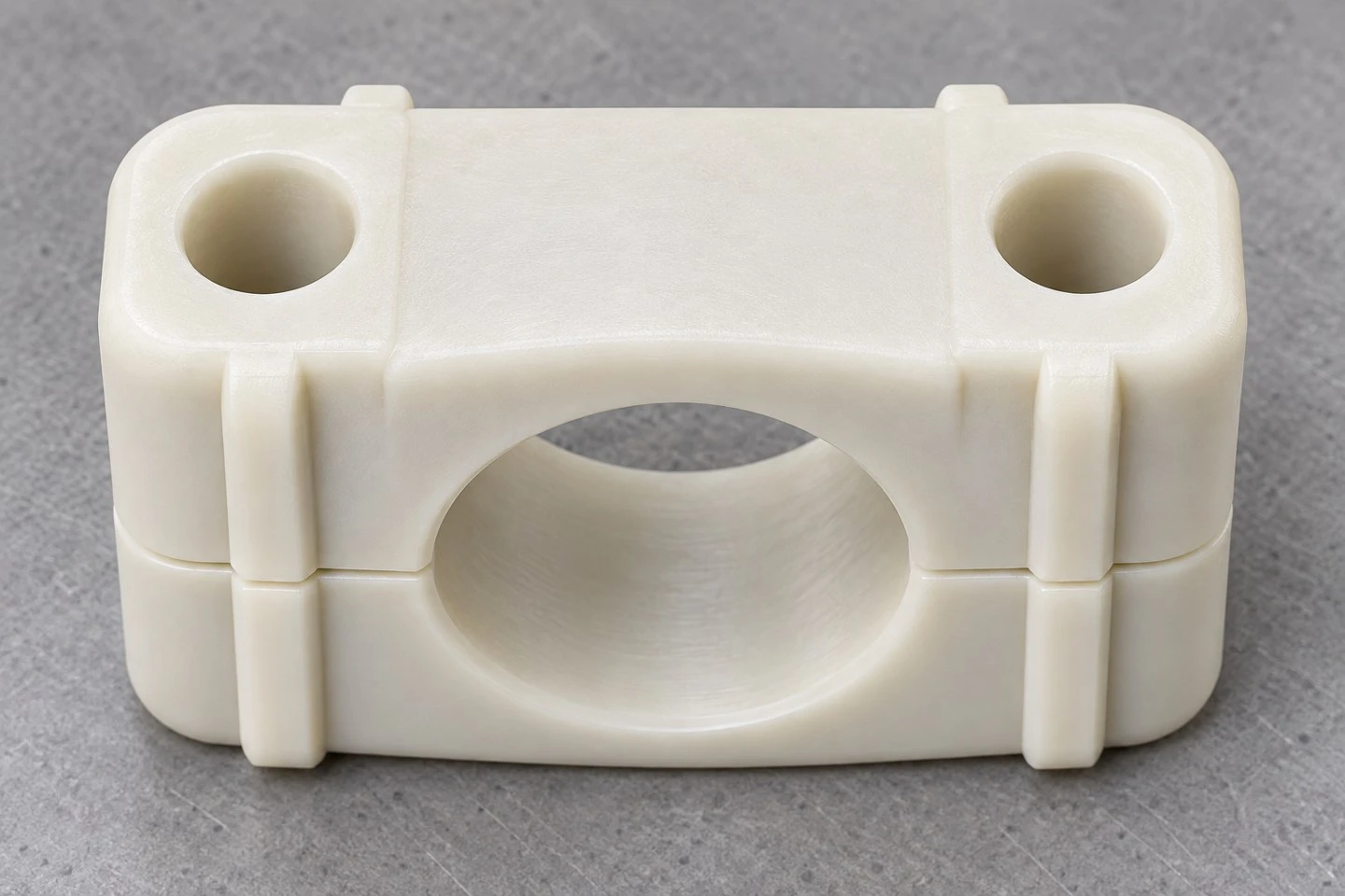 product-1-1 Top view of a custom nylon split pipe clamp showing the mounting holes and exterior reinforcing features