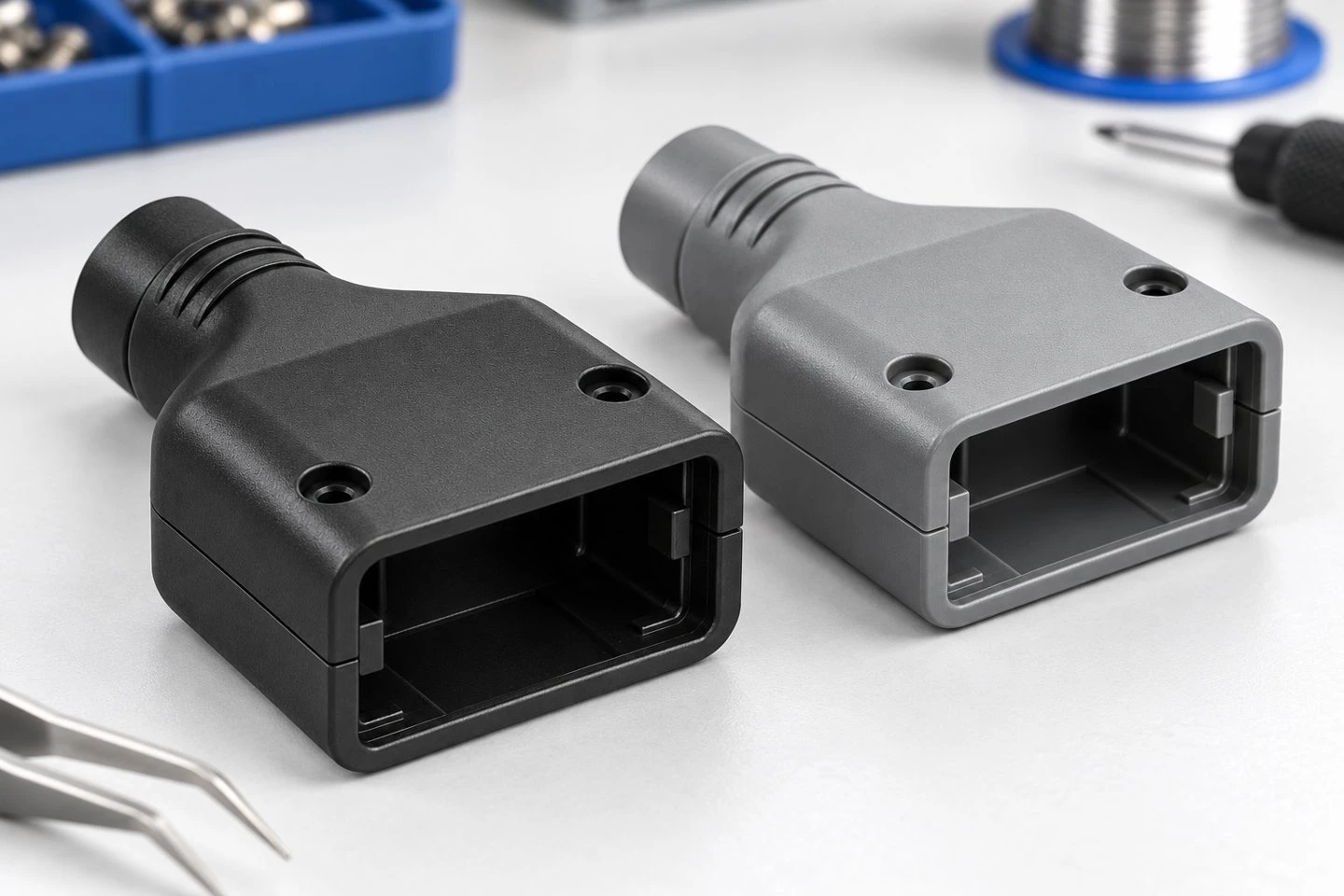 Black and gray custom connector backshell housing concepts on an electronics assembly workbench