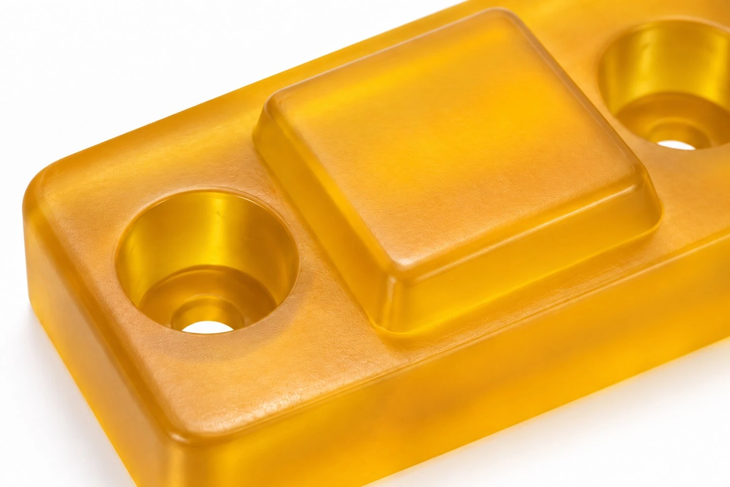 product-1-1 Close view of a custom polyurethane buffer block showing recessed mounting holes and raised contact pad