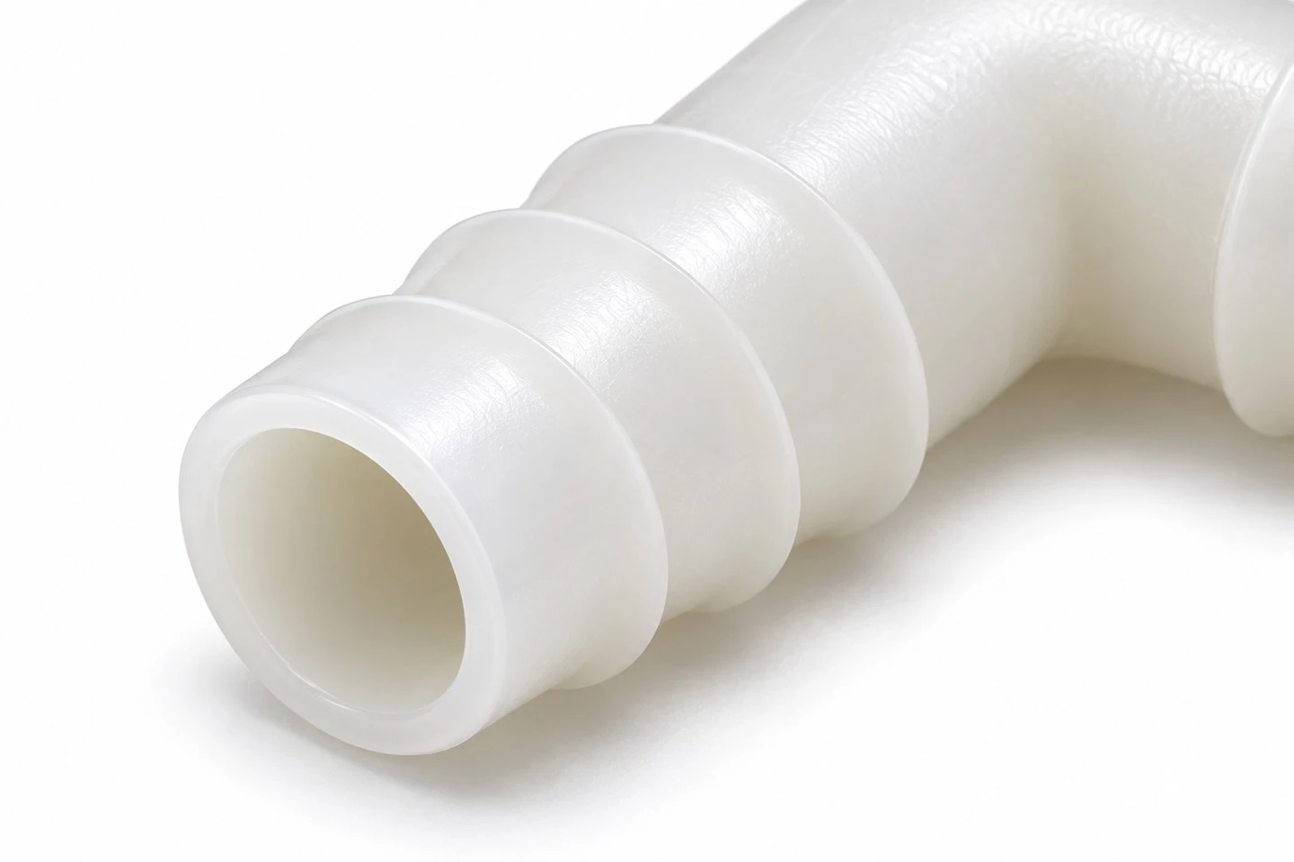 product-1-1 Close view of a custom polypropylene hose elbow showing the barbed tail profile and open bore